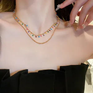 Detailed view of an elegant double-layered gold necklace featuring colorful drop charms