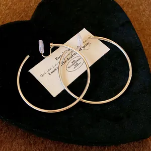 Detail view of minimalist silver hoop clip-on earrings with comfort silicone pads