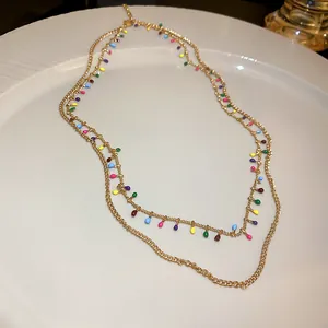 Detailed view of a gold-tone double-layered necklace with vibrant colorful drops.