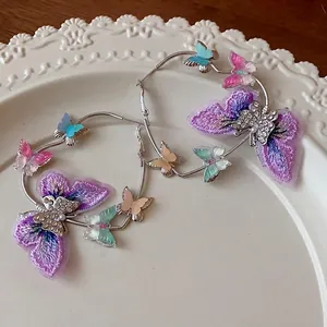Large silver hoop earrings with embroidered butterfly charms and crystals
