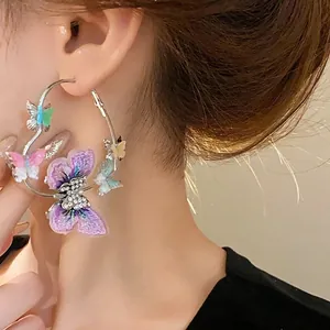 Elegant silver hoop earrings featuring embroidered and rhinestone butterfly charms