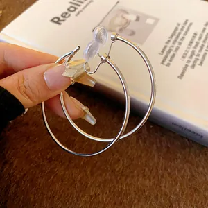 Close-up of silver minimalist hoop clip-on earrings with comfort pads.