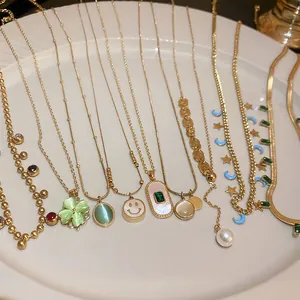 Detail view of titanium steel necklaces with emerald zircon and clover pendants.