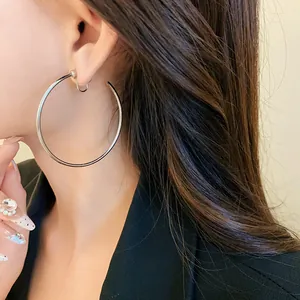 Macro view of minimalist silver hoop ear clips for women shown on an Asian model