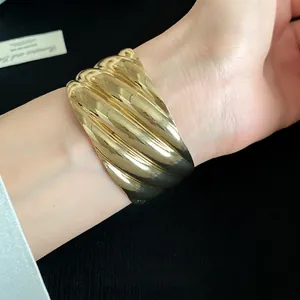 High-end gold-tone chunky metal cuff bracelet featuring wave texture in minimalist style