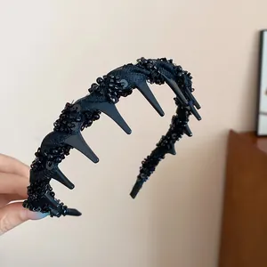 Detailed view of a stylish black beaded headband with teeth, vintage hair accessory