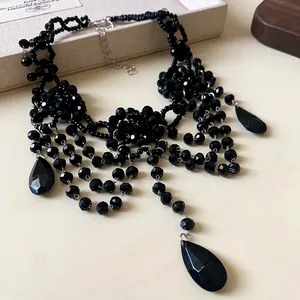 Gros plan d'un collier de cristal noir multicouche avec pendentifs en goutte