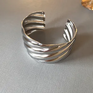 Detailed macro view of a silver wavy textured metal cuff bracelet with minimalist style.