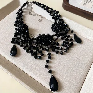 Gros plan détaillé du collier multicouche en cristal noir avec pendentif goutte élégant