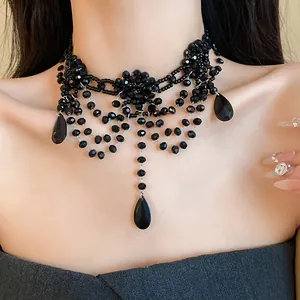 Gros plan d'un choker noir perlé multicouche avec fleur et pendentifs en goutte.
