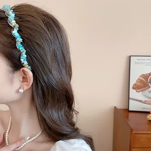 Detail view of a retro blue irregular acrylic stone headband worn by a model