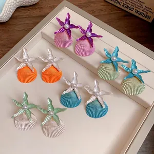 Vibrant shell and starfish stud earrings with pearl accents for stylish beach vacations.