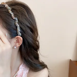 Close-up of retro acrylic crushed stone headband worn by a model with wavy hair