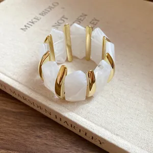 Nahaufnahme der weißen Acryl-Diamantsegmente und Goldakzente an diesem elastischen Armband.
