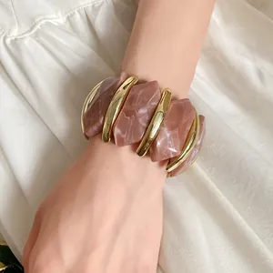 Detailansicht des rosa marmorierten Acryl- und Goldmetall-Stretch-Armbands für Damen
