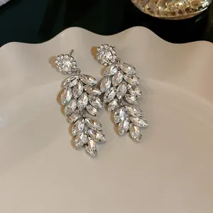 Detailed shot of sparkling crystal-encrusted wheat ear leaf earrings with silver needles
