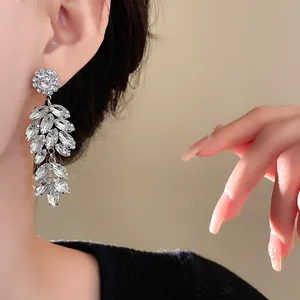 Close-up of elegant sparkling marquise-cut crystal wheat ear drop earrings on model