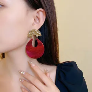 Vintage geometric U-shaped drop earrings with marbled red resin and gold accents