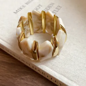 Detailansicht der cremefarbenen Marmor-Acryl-Segmente und Goldakzente am Armband