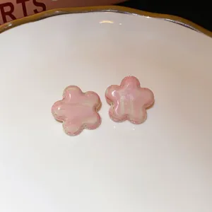 Close-up detail of sweet pink marble textured flower stud earrings with silver needles