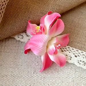 Gros plan d'une pince à cheveux fleur rose avec des pétales sur une toile de jute rustique