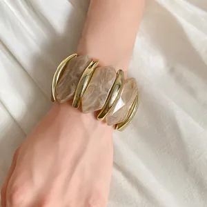 Nahaufnahme eines unregelmäßigen diamantförmigen elastischen Acrylarmbands am Handgelenk
