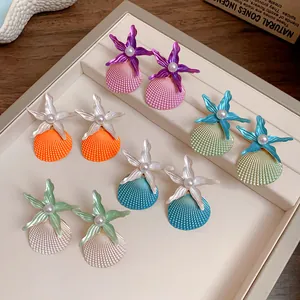 Macro view of colorful starfish and seashell earrings with pearls on jewelry tray