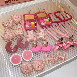 Close-up of pink themed earring set featuring hearts, bears, and geometric shapes