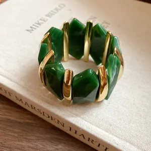 Detailansicht eines elastischen Armbands mit grünen Acrylperlen und Gold