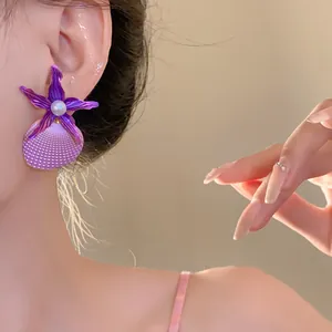 Detailed view of fashionable purple starfish and seashell earrings with pearl accent