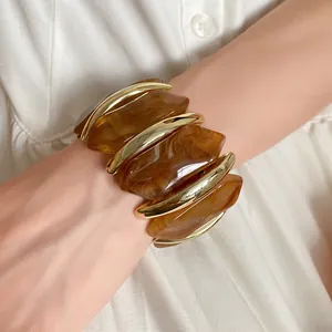 Detailansicht von bernsteinfarbenem Acryl-Armband mit unregelmäßigen Rauten und Goldakzenten