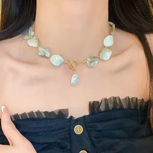 Detailansicht einer Halskette aus unregelmäßigen Muschelstücken mit goldenem Knebelverschluss