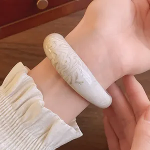 Close-up view of a marbled acrylic bangle featuring an elegant ink-wash pattern on a wrist