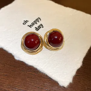 Primer plano de pendientes de perlas vintage con diseño envuelto en oro en tarjeta