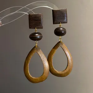 Close-up detail view showing the natural wood grain texture of vintage ethnic drop earrings.