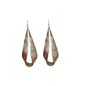 Elegant long irregular twisted metal drop earrings with a textured matte gold finish