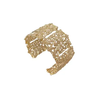 Elegante brazalete ancho dorado con intrincados patrones florales de filigrana calada