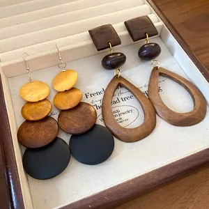 Detail shot of handcrafted wooden earrings with natural textures in a jewelry box