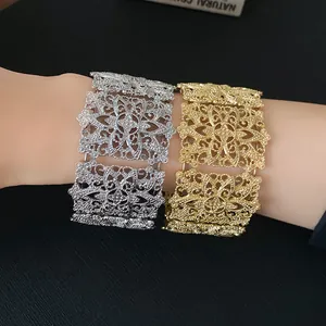 Detalle de brazaletes anchos calados en oro y plata con diseño floral