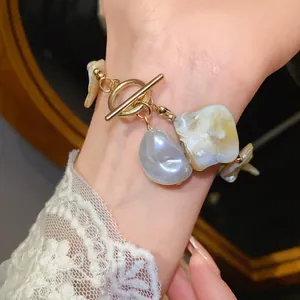 Detailansicht eines Armbands aus unregelmäßigen Muscheln und Perlen mit goldenem T-Verschluss