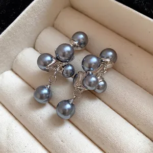 Elegant grey pearl grape cluster drop earrings displayed on a beige velvet jewelry tray