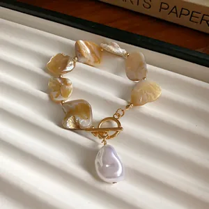 Detailansicht eines gelben Muschelarmbands mit Barockperle und goldenem OT-Verschluss