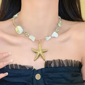 Nahaufnahme einer Muschelkette mit einem strukturierten goldenen Seestern-Anhänger.