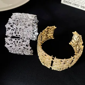 Detalle exquisito de pulseras anchas caladas de moda en acabados dorado y plateado