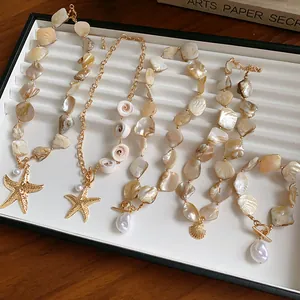 Detailansicht eines Schmucksets im Strandstil mit unregelmäßigen Muscheln und Seesternen