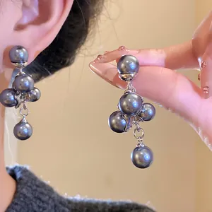 Close-up of elegant grey pearl grape cluster earrings with vintage silver needles