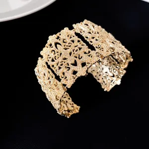 Brazalete dorado con intrincado motivo floral calado y diseño de filigrana texturizada