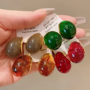 Close-up detail of colorful resin drop earrings with gold-tone metal backing