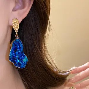 Detailed macro view of retro irregular blue drip oil drop earrings worn by a model.