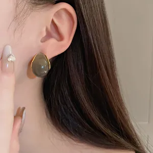 Detailed view of vintage Maillard style teardrop geometric resin earrings worn on model ear